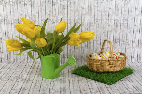 Yellow tulips with Easter eggs on a textured background