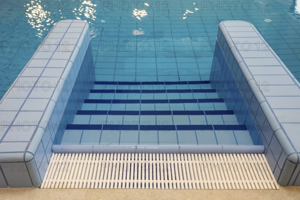Tranquil pool steps gently leading into the refreshing, clear blue water, perfect for peaceful relaxation