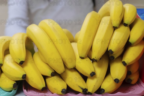 A pile of yellow ripe bananas on a shop counter