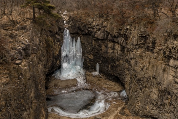 Looking down on frozen waterfall in deep crater located in Gyeonggi province of South Korea