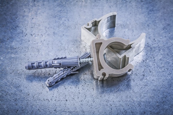 Stack of pipe clamps on metallic background construction concept
