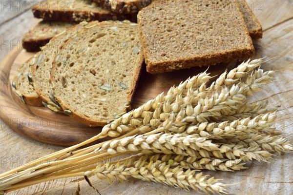 Cereal, wheat and bread on a wooden table. Different types of bread on wood