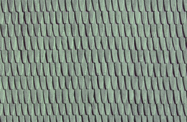 Green roof tiles create a uniform, textured pattern in a repetitive design.Belarus