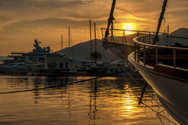 View of Harbor and marina with moored yachts and motorboats at sunset