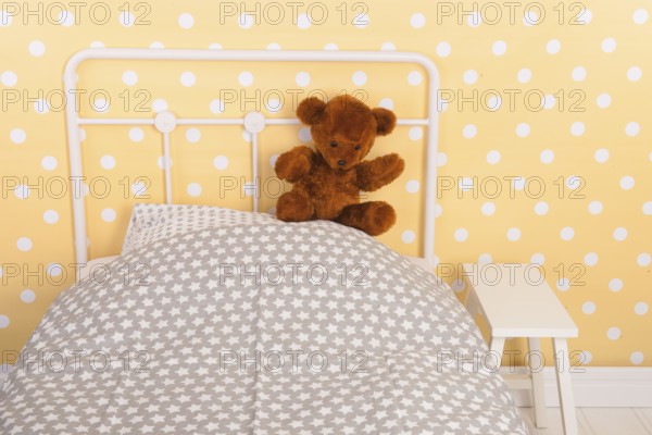 Bedroom with teddy bear sitting on bed