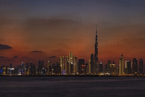 A colorful picture of Downtown Dubai at sunset, with the Burj Khalifa towering the other high rises