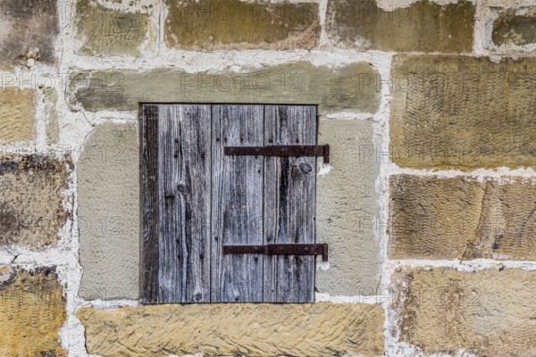 Medieval architecture background with a stone wall and a small wooden trap door