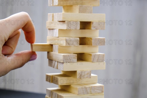 Building from wooden blocks. Wood blocks stack game with Hand on background. Conceptual of Teamwork. Block tower with architecture model, Risk of management and strategy plan, growth business success process