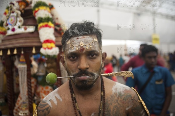 31/01/2018, Singapore, Republic of Singapore, Asia, A devout Hindu man's cheeks are pierced with a metal skewer as he prepares for the Thaipusam festival procession at the Sri Srinivasa Perumal temple in Little India, leading to the Sri Thendayuthapani temple on Tank Road, 4 kilometres away