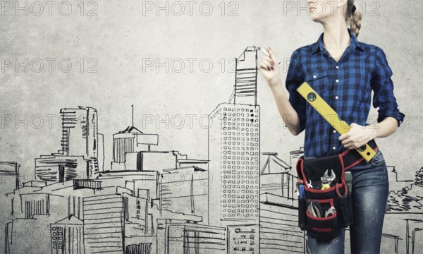 Attractive blond woman builder with ruler in hands draw construction model