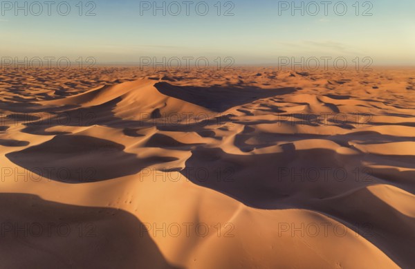 Aerial view on big sand dunes, landscape in Sahara desert at sunrise