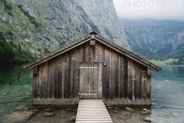 Wooden cottage in beautiful lake in the Alps with misty mood