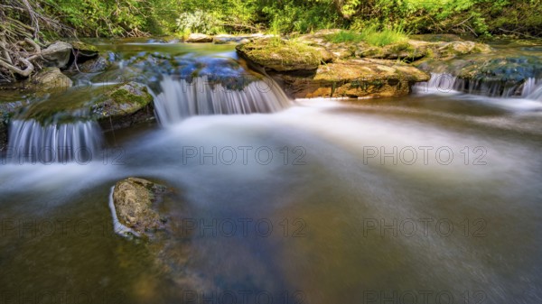At the Felsenbad, a natural water pool with small waterfalls at lake Schussen in Upper Swabia