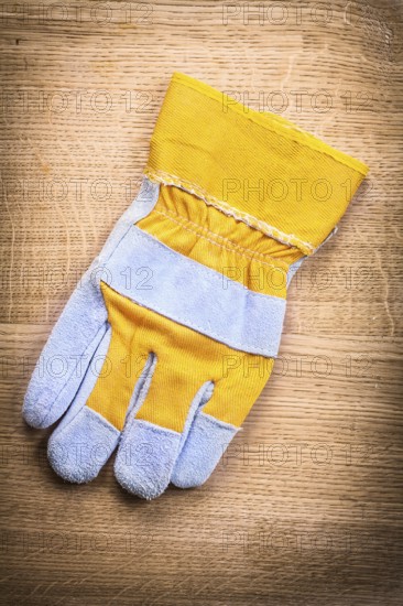 Protective work glove on wooden board construction concept