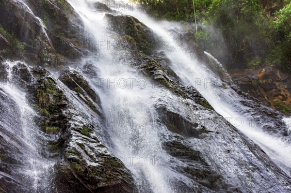 Beautiful waterfall with water flowing between the rocks and the forest in Minas Gerais, Brazil