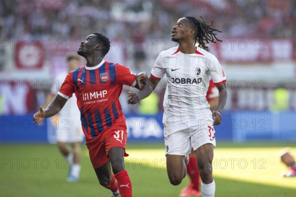 Football match, Sinlord CONTEH 1. FC Heidenheim left and Jordy MAKENGO SC Freiburg follow the ball looking to the left, football stadium Voith-Arena, Heidenheim