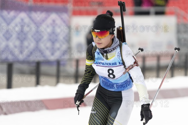 Korean sportswoman biathlete Lee Hyunju South Korea skiing at finish after rifle shooting during Open regional youth biathlon competitions East Cup. Kamchatka Peninsula, Russia, Apr 12, 2019