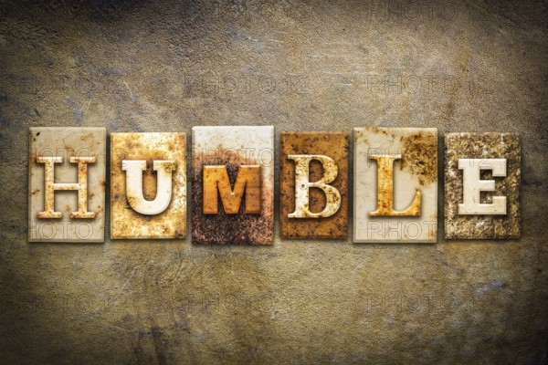 The word HUMBLE written in rusty metal letterpress type on an old aged leather background