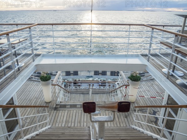 View of the deck of a ship at sunset with railings and a wooden staircase, svaneke, bornholm, baltic sea, denmark, scandinavia