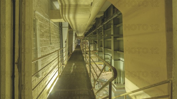 Industrial interior with a raised walkway and metal grating, surrounded by pipes and railings, Bad am Park, Lost Place, Essen, North Rhine-Westphalia, Germany