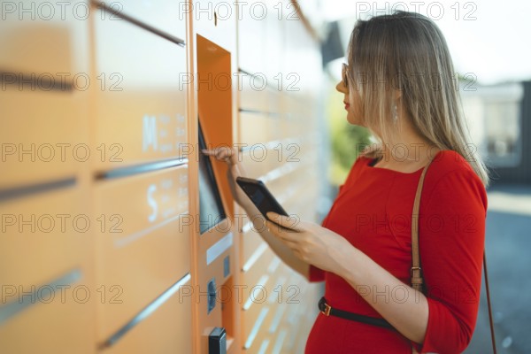 Woman picks up mail from automated self-service post terminal machine