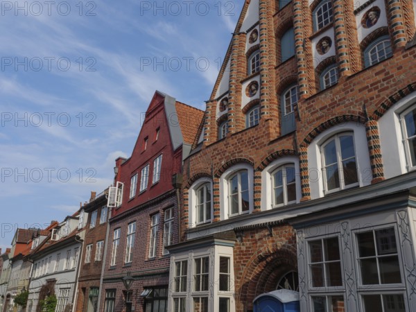 Street scene with historic brick buildings under a blue sky, lüneburg, germany