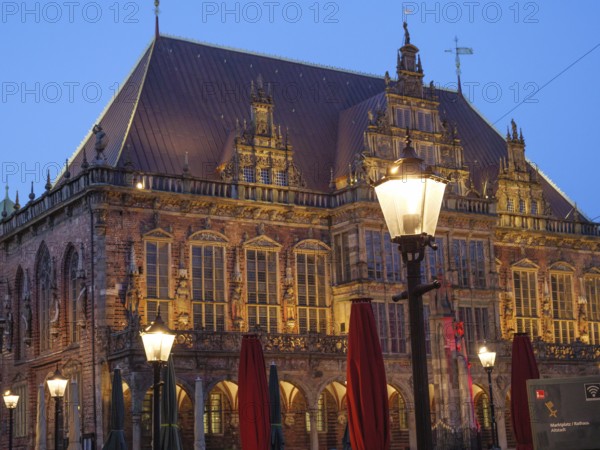 Night shot of a historic building with Gothic architecture, illuminated by lanterns and a cosy atmosphere, Bremen, Germany