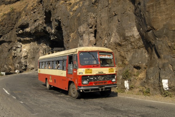 Road and Tunnel constructed by cutting very hard black rock of Sahyadri mountain and State Transport bus at Malshej Ghat, District Thane, Maharashtra, India