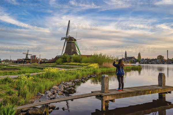 Dutch Windmill at Zaanse Schans Village with woman tourist, Amsterdam Netherlands
