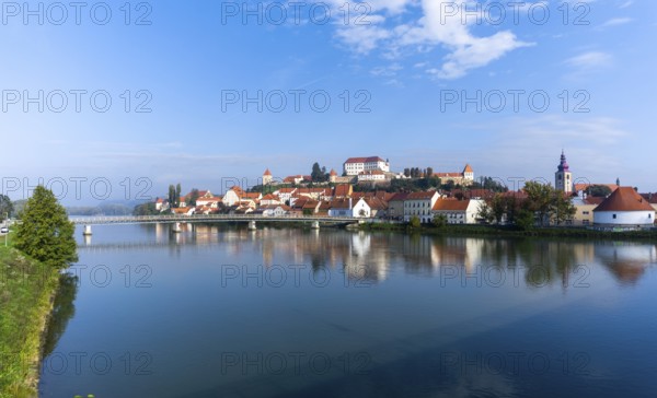 Ptuj, Slovenia, 11 October, 2022: panorama cityscape of Ptuj with the hilltop castle and reflections in the Drava River