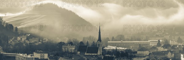 Morning atmosphere and morning fog over the Calvary, Waasenkirche church and old grammar school, Göss Abbey in the background, panoramic view, Leoben, Styria, Austria