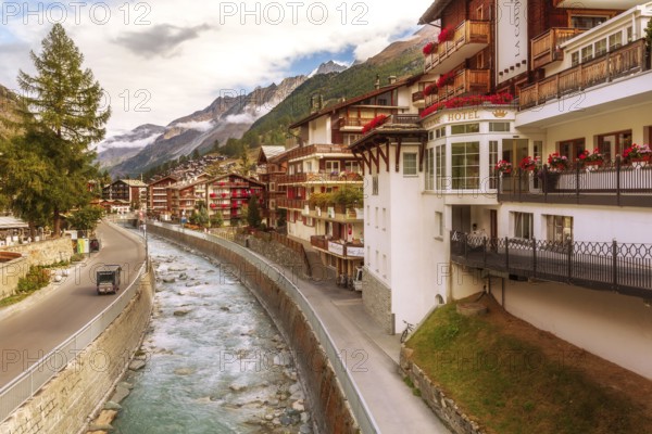 Zermatt, Switzerland, October 7, 2019: Alpine village panorama, Swiss Alps, traditional wooden houses, snow mountains and river