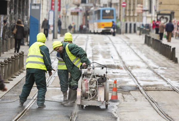 Sofia, Bulgaria - February 27, 2016: Transportation workers are cutting the asphalt at the tram rails during a repairment