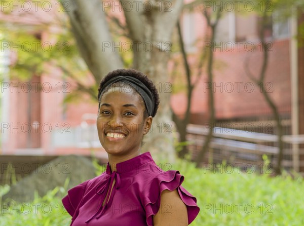 Woman in a purple blouse smiling in a green outdoor park setting, Taken in Daejeon, South Korea