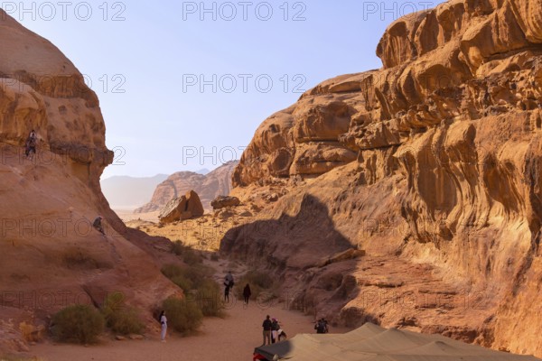 Wadi Rum, Jordan, November 1, 2022: Desert landscape with orange sand and rock formations, people