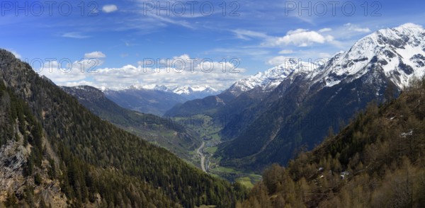 Beautiful top view panorama of high snow-covered mountains and valley with road and village in Switzerland at spring