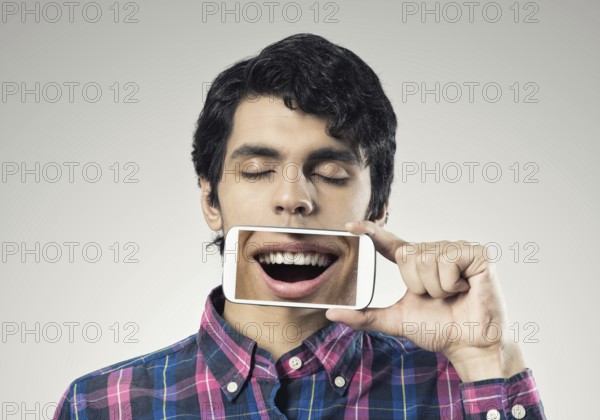 Young man holding smartphone with smile on screen