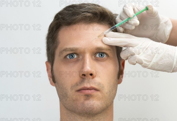 Handsome man is getting injection. Concept of aesthetic beauty. Place for your text