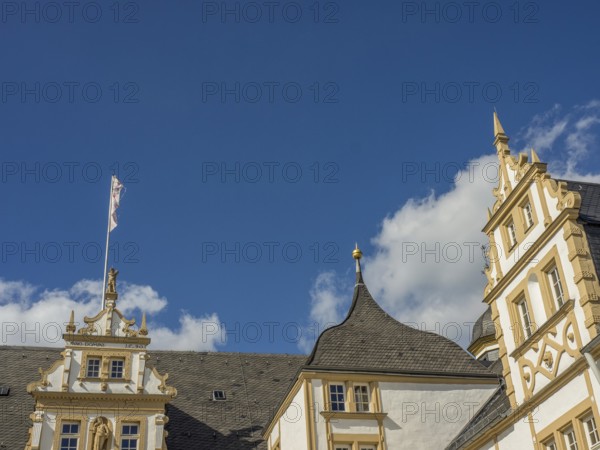 Historic castle with yellow and white façade and towers in front of a blue sky with clouds, Neuhaus Castle, Germany