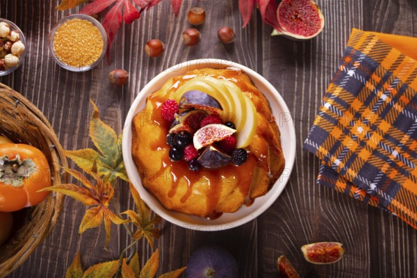 Delicious homemade autumn cake with figs and frozen berries for celebrating Thanksgiving day or Halloween. Top view