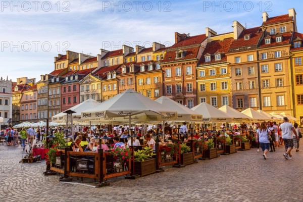 Warsaw, Poland, June 24, 2019: Colorful houses and cafe, restaurant in Market Square in the Old Town of polish capital, sunset view