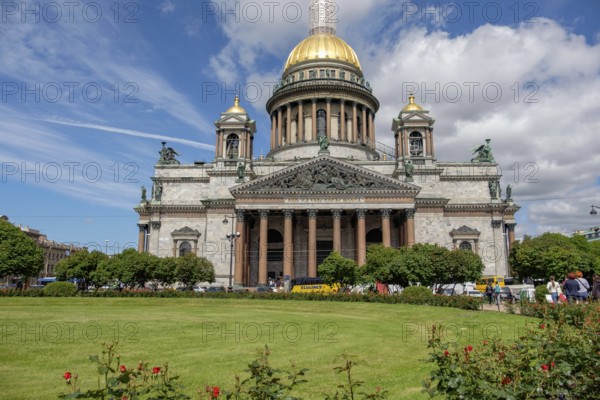 Large cathedral with golden dome, surrounded by greenery and covered by a partly cloudy sky, saint petersburg, baltic sea, russia