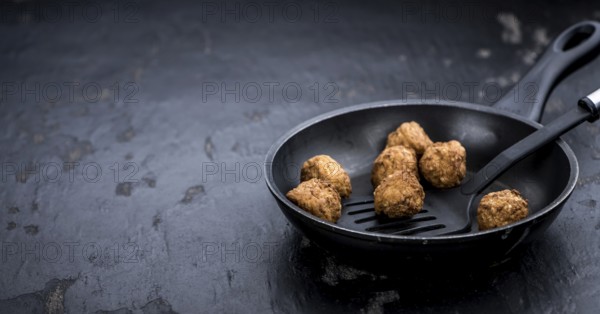Slate slab with homemade Meatballs (selective focus, close-up shot)