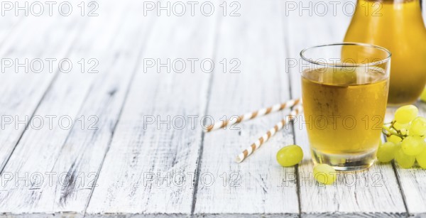 Healthy Grape Juice on a wooden table as detailed close-up shot (selective focus)