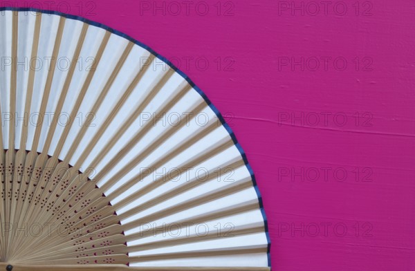 Typical Japanese hand fan made on the wooden pink table
