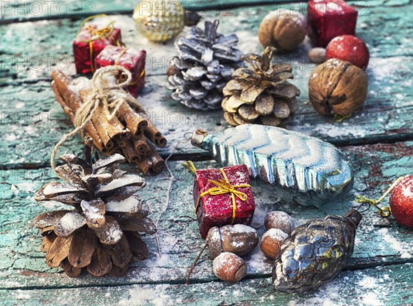 Gifts and decorations for Christmas on wooden background strewn with pine cones and spices