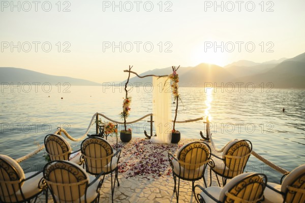 Wooden arch for the wedding ceremony at sunset. On the shore of the Bay of Kotor, Tivat, Montenegro