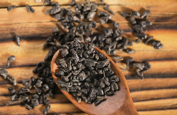 Dry puer tea leaf in wooden spoon on the rustick table