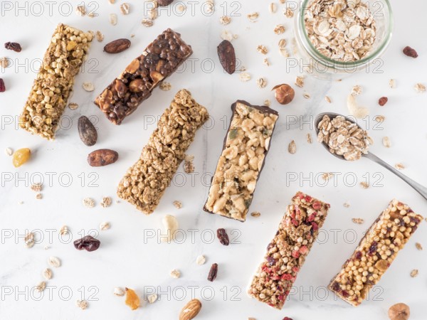 Granola bar with copy space. Set of different granola bars on white marble table. Shallow DOF. Top view or flat lay