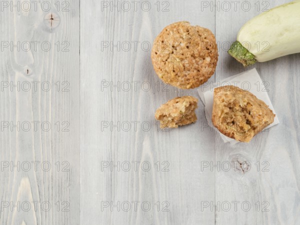Top view of muffin with zucchini, carrots, apple and cinnamon on gray wooden background. Sweet vegetables homemade muffins. Toddler-friendly recipe idea. Copy space. Shallow DOF